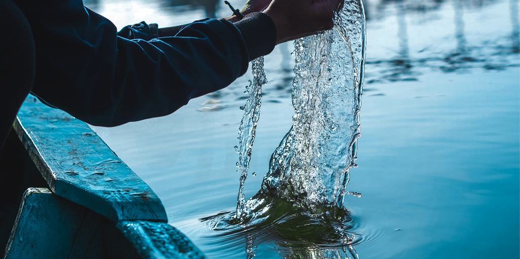A hand scooping flowing water